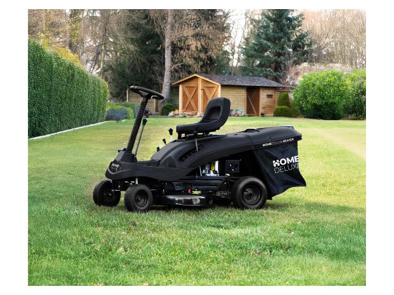Schwarzer HOME DELUXE Aufsitzrasenmäher auf einem Rasen vor einem Holzschuppen.