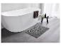 Moderne Badewanne, graue Badmatte und Handtuch.