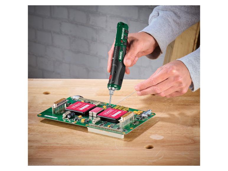 Ein handgehaltener elektrischer Lötkolben lötet eine Platine mit elektronischen Bauteilen.