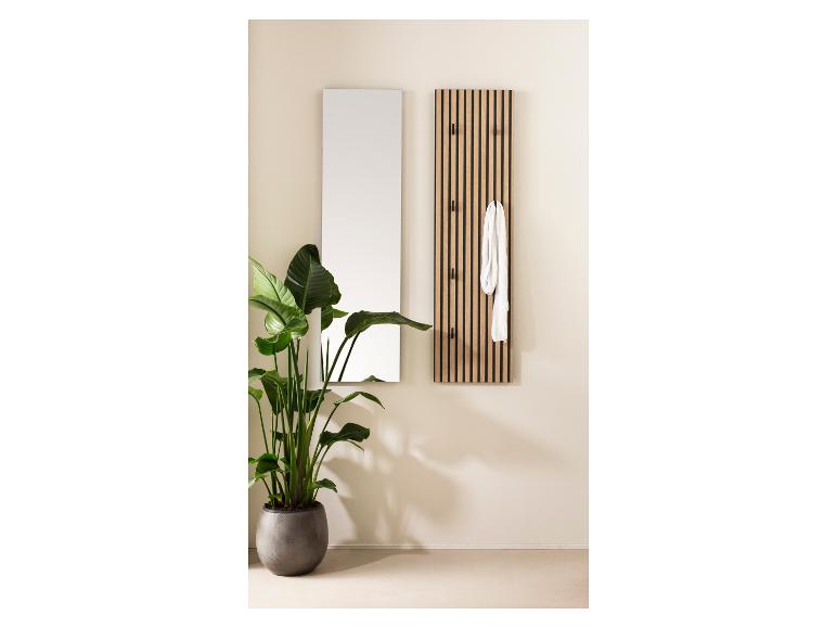 Wandspiegel und Garderobe aus Holz mit einer großen Grünpflanze im Topf.