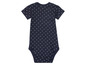Ein dunkelblauer Strampler mit weißen Punkten.