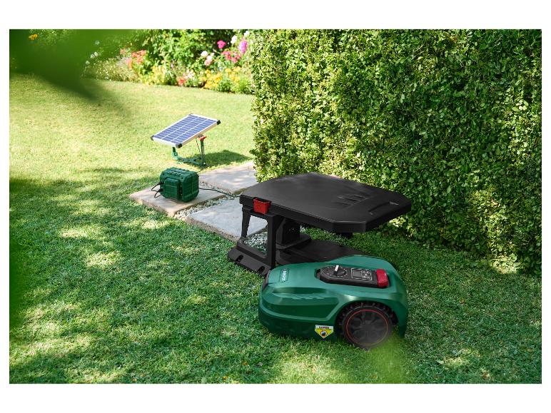 Mähroboter mit Ladestation und Solarpanel im Garten.