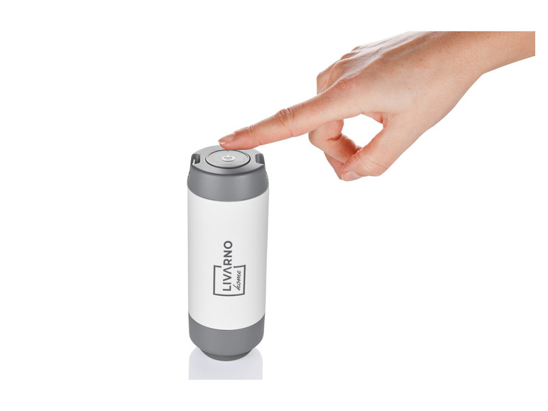 Eine Hand drückt auf den Knopf eines Livarno home kabellosen Ladegeräts.