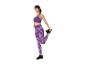 Frau dehnt sich in lila Sport-BH und Leggings.
