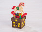 Eine hölzerne Weihnachts-Spieluhr mit einem Schaukelpferd und Geschenken.