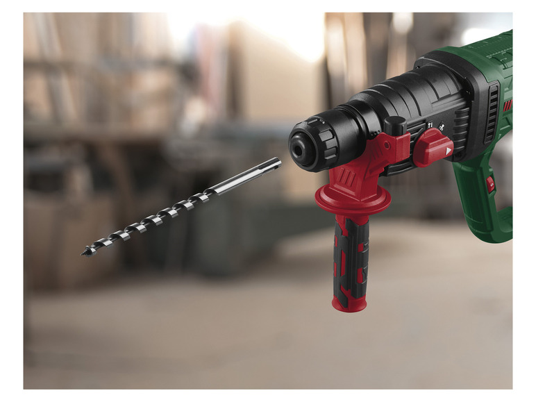 Ein grüner und roter Bohrhammer mit einem Bohrer