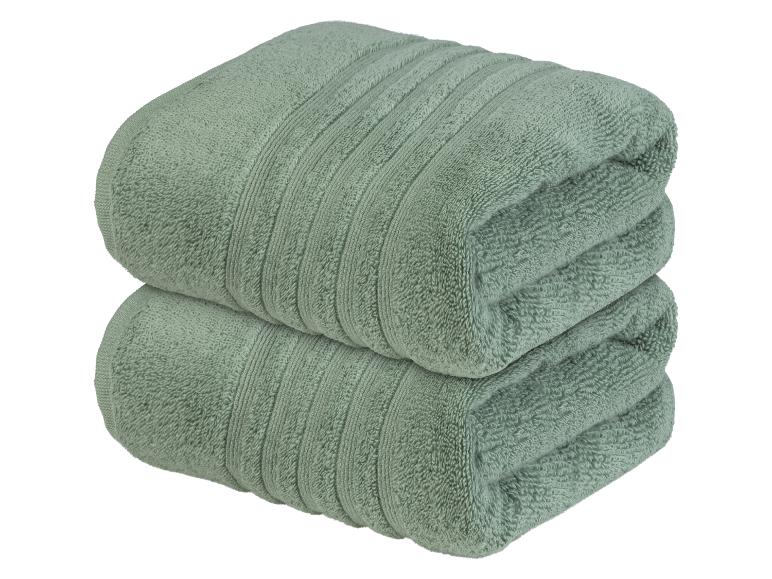 Zwei grüne Handtücher, gerollt und gestapelt.