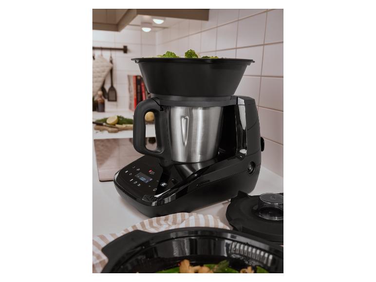 Küchenmaschine mit Dampfgaraufsatz voller Brokkoli auf einer Küchenarbeitsplatte.