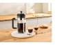 French Press, zwei Tassen Kaffee und Kekse auf einem Holztisch in der Küche.