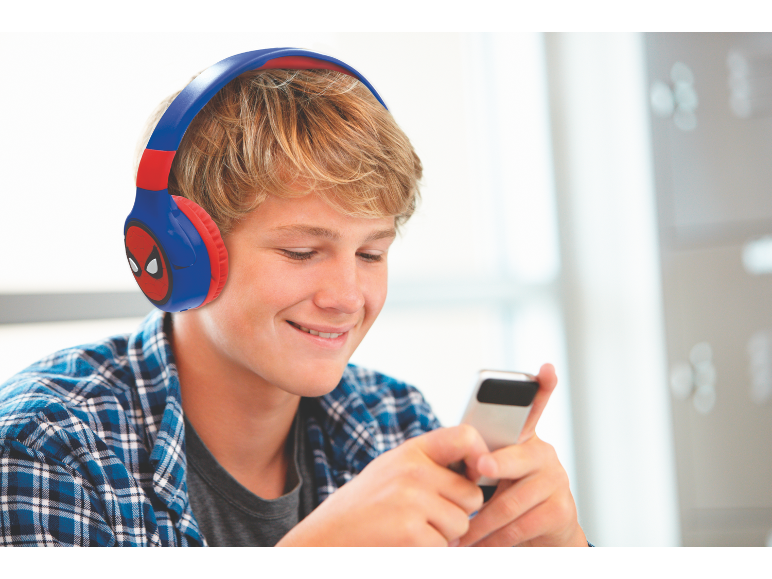 Teenager mit Kopfhörern und kariertem Hemd benutzt ein Smartphone.