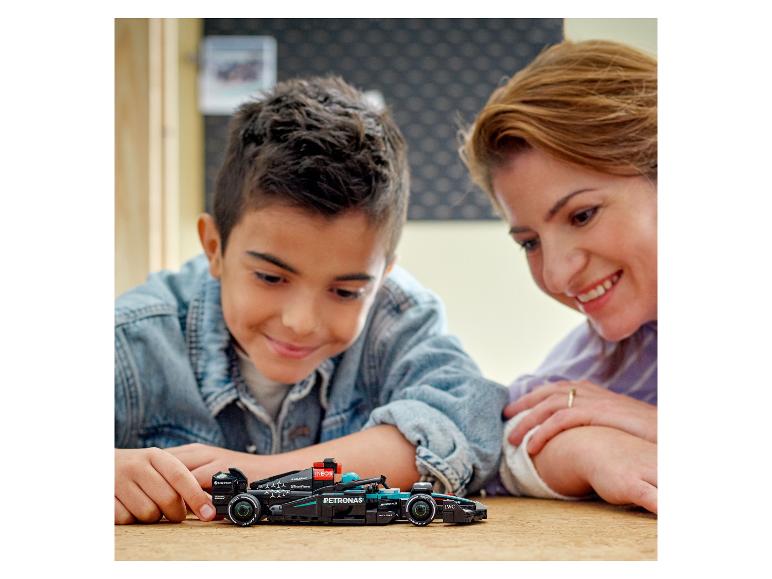 Ein Kind und seine Mutter spielen mit einem LEGO Mercedes-AMG Petronas Formula One™ Team Formel-1-Auto-Modell.