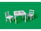 Weißer Kindertisch und zwei Stühle mit Waldtier-Designs auf grünem Hintergrund.