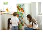 Kinder spielen mit Magnetspielzeug an der Kühlschranktür in der Küche.