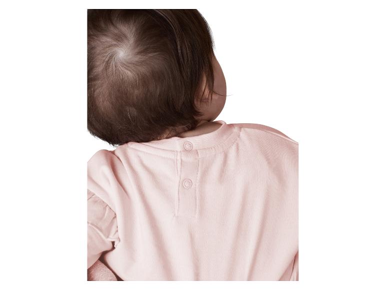 Hinterkopf des Babys und rosa Hemd mit Druckknöpfen.