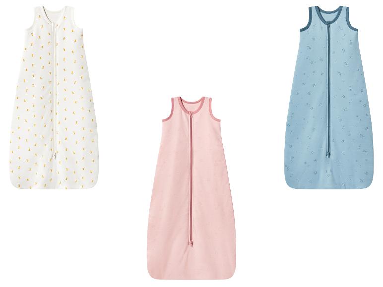 Drei Babyschlafsäcke: weiß mit Giraffen, rosa mit Sternen und blau mit Sternen.