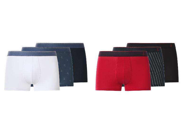 Sechs Herren-Boxershorts in Weiß, Blau, Rot und Schwarz, teilweise mit Mustern.