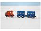 Holzspielzeugzug mit orangefarbener Lokomotive und zwei blauen Waggons auf weißem Boden.