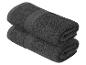 Zwei dunkelgraue Handtücher, gerollt und übereinander gestapelt.