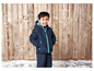 Ein Junge trägt eine blaue Winterjacke und Hose.