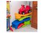 Rotes Spielzeugauto auf einer bunten Rampe im Kinderzimmer.