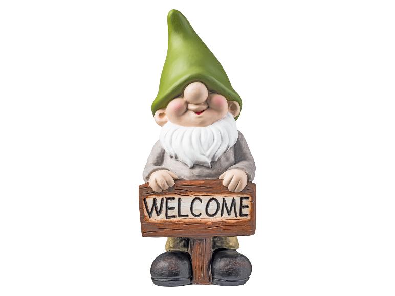 Gartenzwerg mit einem Holzschild 'WELCOME'.