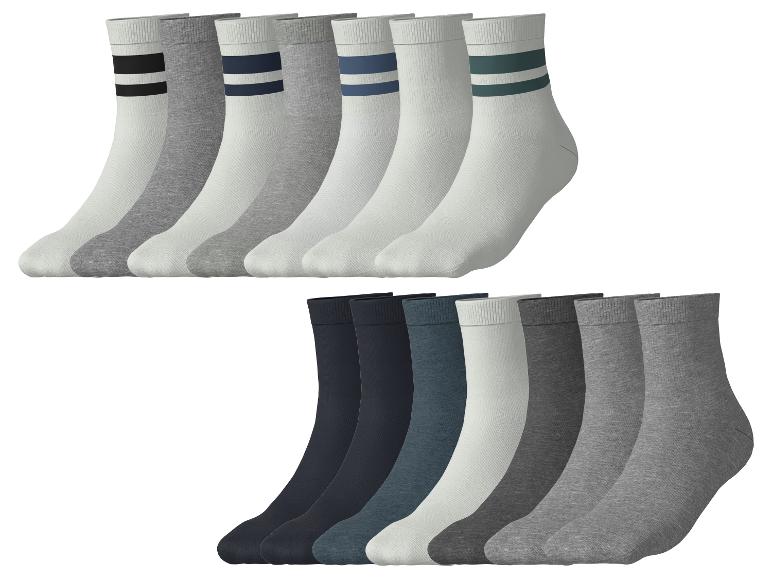 Zwölf Paar Socken in verschiedenen Farben und Stilen, darunter gestreifte und einfarbige.