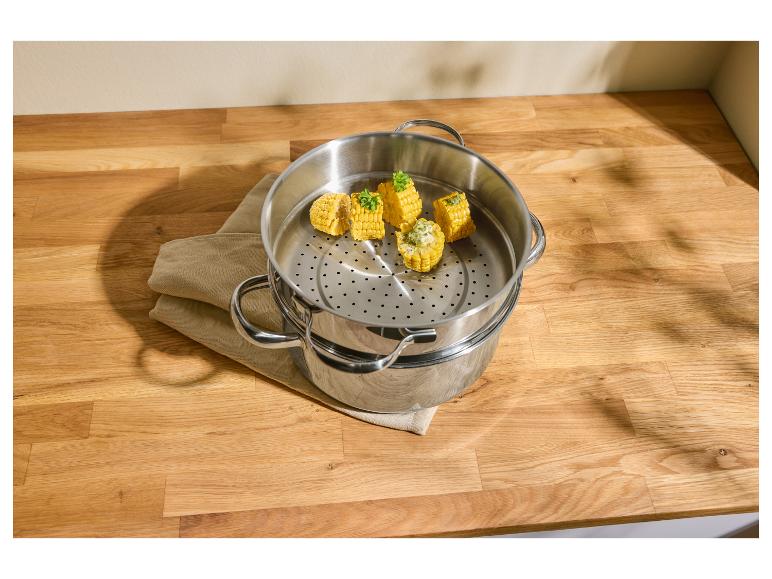 Mais in einem Edelstahl-Dampfgarer auf einer Holzarbeitsplatte.