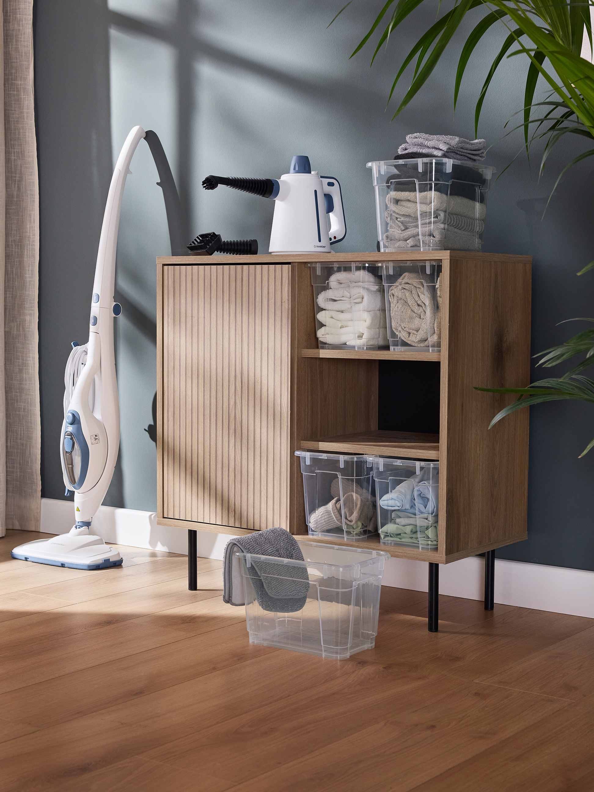 Boden-Dampfreiniger und Hand-Dampfreiniger mit transparenten Aufbewahrungsboxen und Handtüchern.