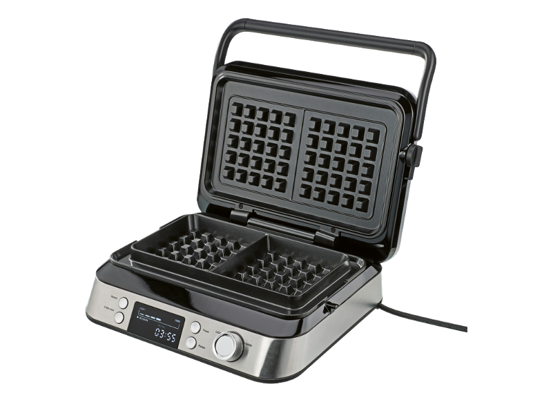 Geöffnetes Waffeleisen aus Edelstahl mit digitalem Display auf schwarzem Hintergrund.