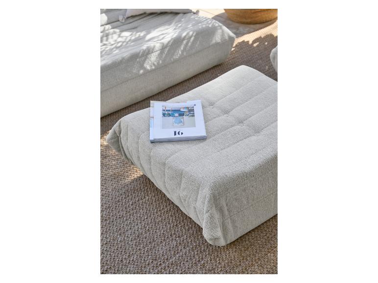 Hellgraue Polsterhocker auf einem gewebten Teppich, mit einer Zeitschrift darauf.