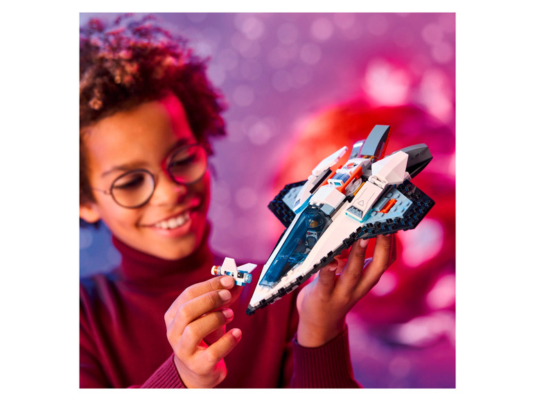 Ein Kind hält ein LEGO Raumschiff fest.