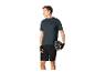 Mann in Sport-T-Shirt, Shorts und Handschuhen, hält einen Fahrradhelm.