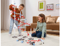 Kinder spielen im Wohnzimmer mit einer großen, bunten Murmelbahn.