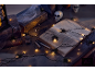 Halloween-Dekoration mit Spinnenlichtern, alten Büchern und Totenköpfen auf dunklem Tisch.