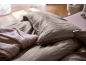 Gestreifte Bettwäsche und eine weiche Decke im Schlafzimmer.