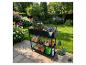 Schwarzes Gartenregal mit Pflanzkasten, Werkzeugen und blühenden Pflanzen auf einer Terrasse.