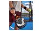 Padel-Schläger und Ball, gehalten von einem Spieler auf einem Padel-Platz.