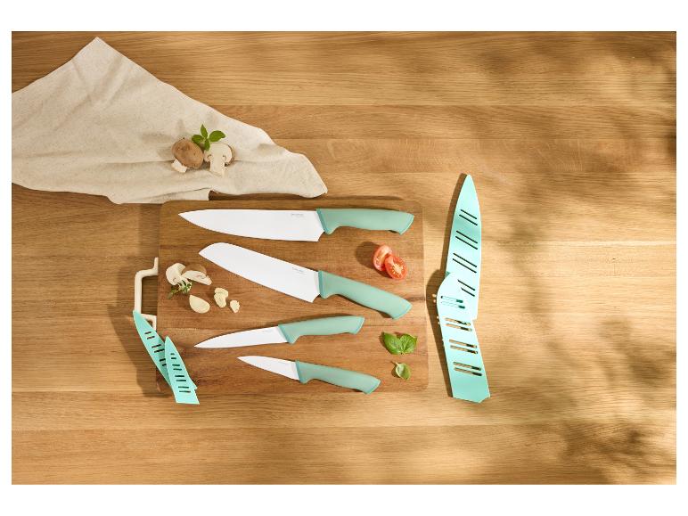 Messerset auf Schneidebrett mit Pilzen, Knoblauch, Tomate und Basilikum.