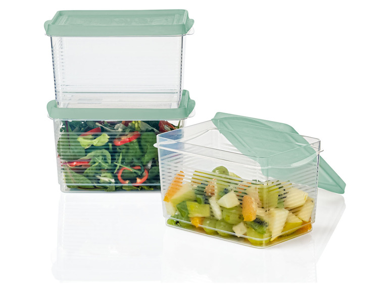 Drei transparente Aufbewahrungsbehälter mit grünen Deckeln, gefüllt mit Salat und Obst.
