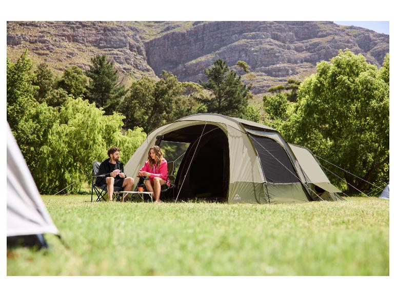 Campingzelt mit einem Paar, das draußen in der Natur Karten spielt.