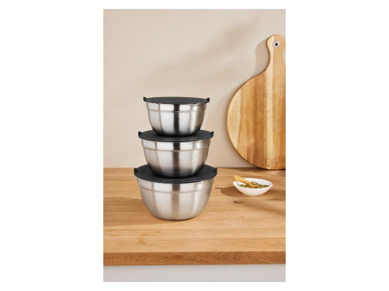 Drei gestapelte Edelstahlschüsseln mit schwarzen Deckeln auf einem Holztisch.