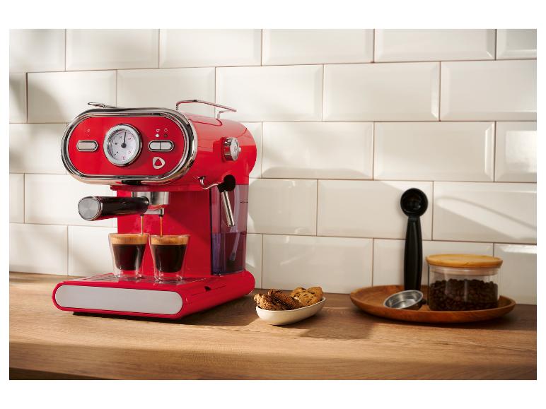 Rote Retro-Espressomaschine brüht Kaffee auf einer Holztheke.