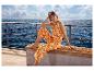 Eine Frau in einem ESMARA® Jumpsuit mit orange-weißem Muster sitzt auf einem Schiffsdeck.