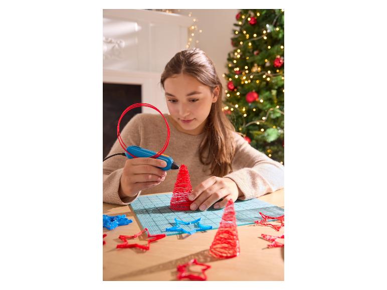 Ein Mädchen benutzt einen 3D-Stift, um einen roten Weihnachtsbaum zu basteln.