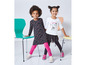 Zwei Mädchen in Leggings und T-Shirts mit Blumenmuster.