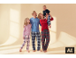 Glückliche Familie in passenden karierten Pyjamas, Mutter hält Baby.