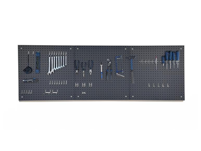 Graue Lochwand mit verschiedenen Werkzeugen, darunter Schraubenschlüssel, Zangen und Schraubendreher.