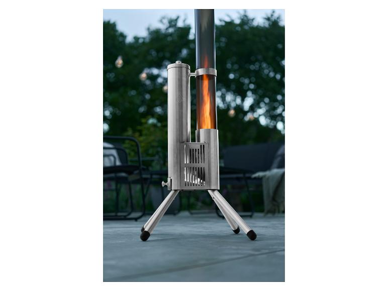 Silberner Terrassenheizer mit Flamme in einem Glasrohr, draußen aufgestellt.