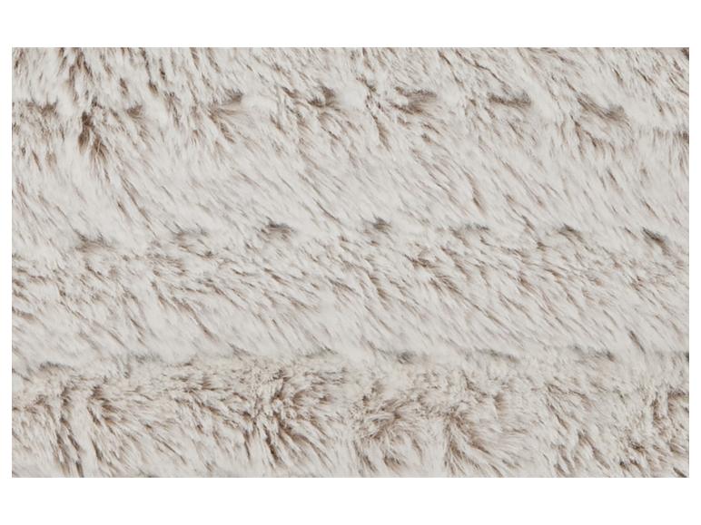 Nahaufnahme einer weichen, hellen Kunstfelltextur mit subtilen Brauntönen.