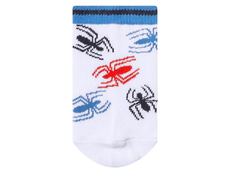 Weiße Socke mit Spinnenmuster in Schwarz, Rot und Blau, und blauen Streifen am Bündchen.